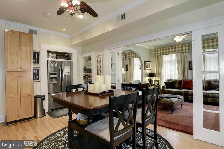 Dining area with a dark wood table beside the kitchen and adjoining living room.