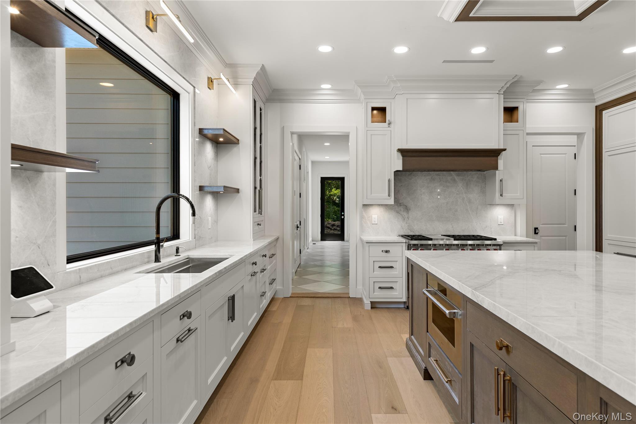 Kitchen with marble counters, a large wood-paneled island, and a professional range.