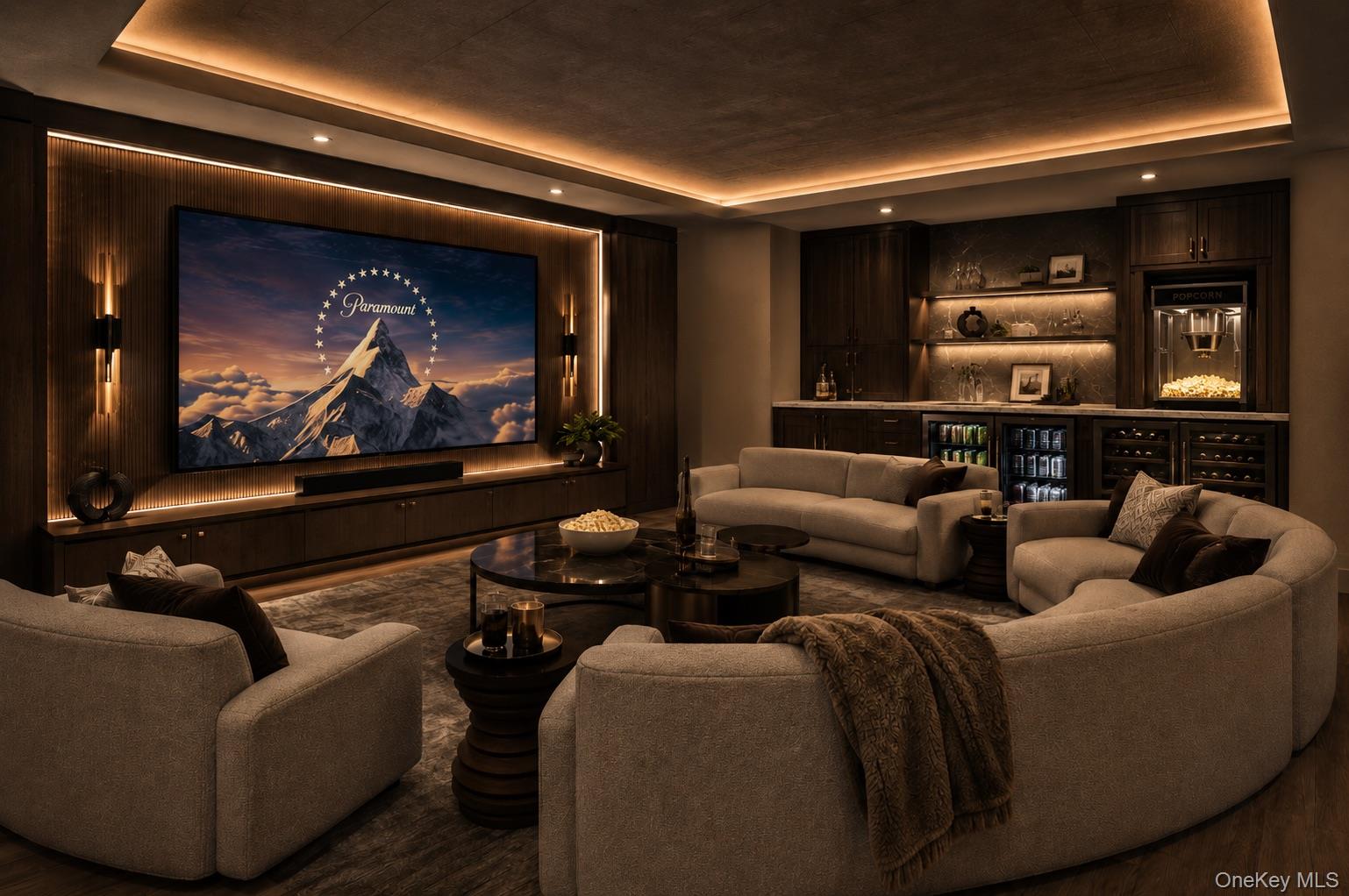 Furnished home theater with a large screen, curved sectional seating, and a built-in bar with popcorn machine.