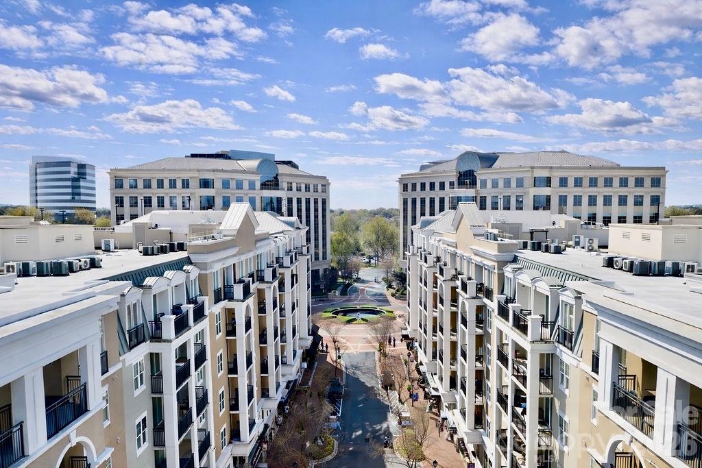Aerial view of residential buildings with balconies overlooking a landscaped courtyard.