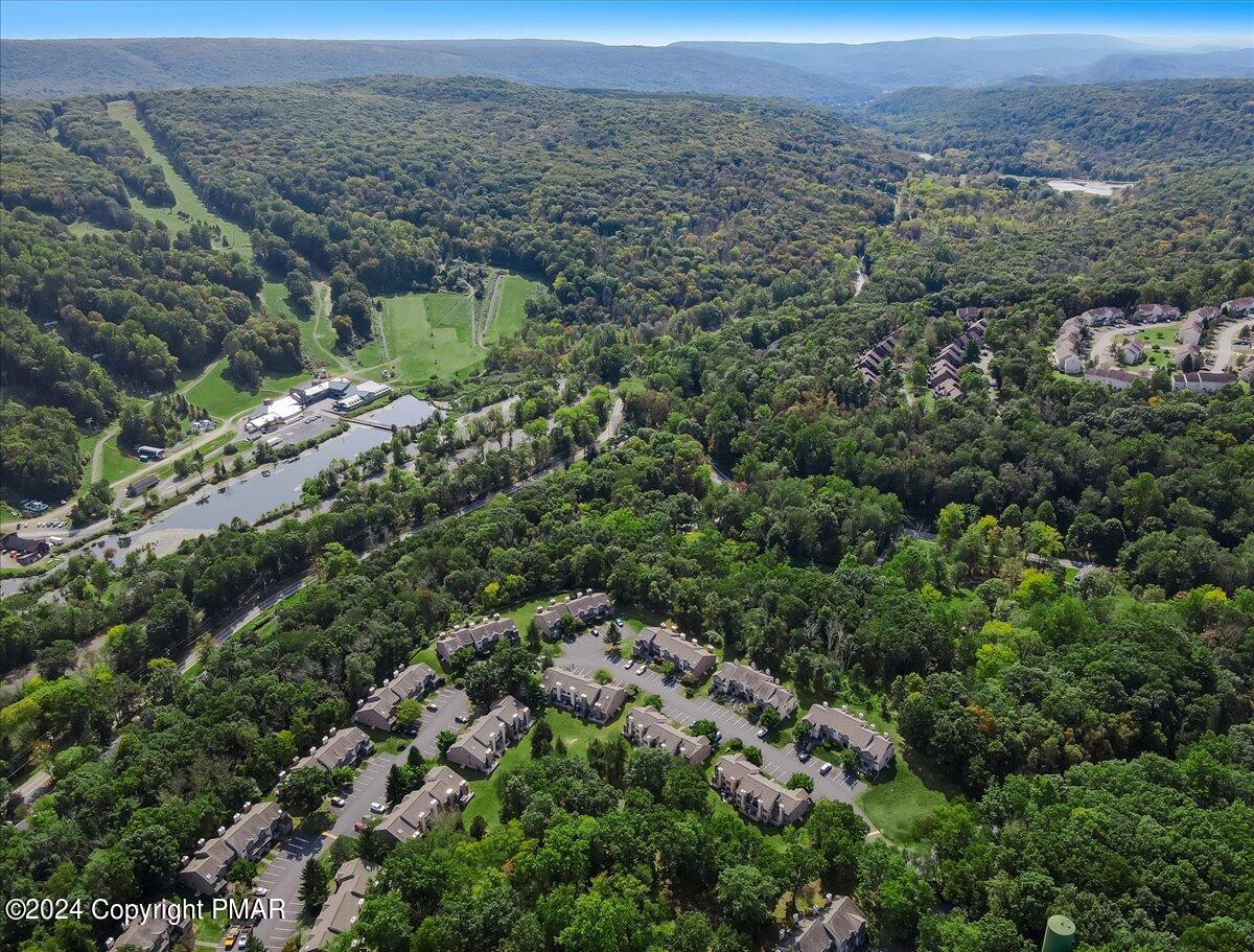 Aerial view of wooded East Stroudsburg homes and community, with distant mountain ridges.