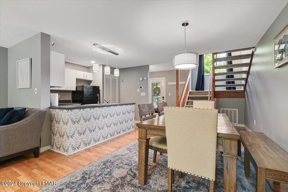 Open-plan kitchen and dining area with a patterned breakfast bar and open wood staircase.