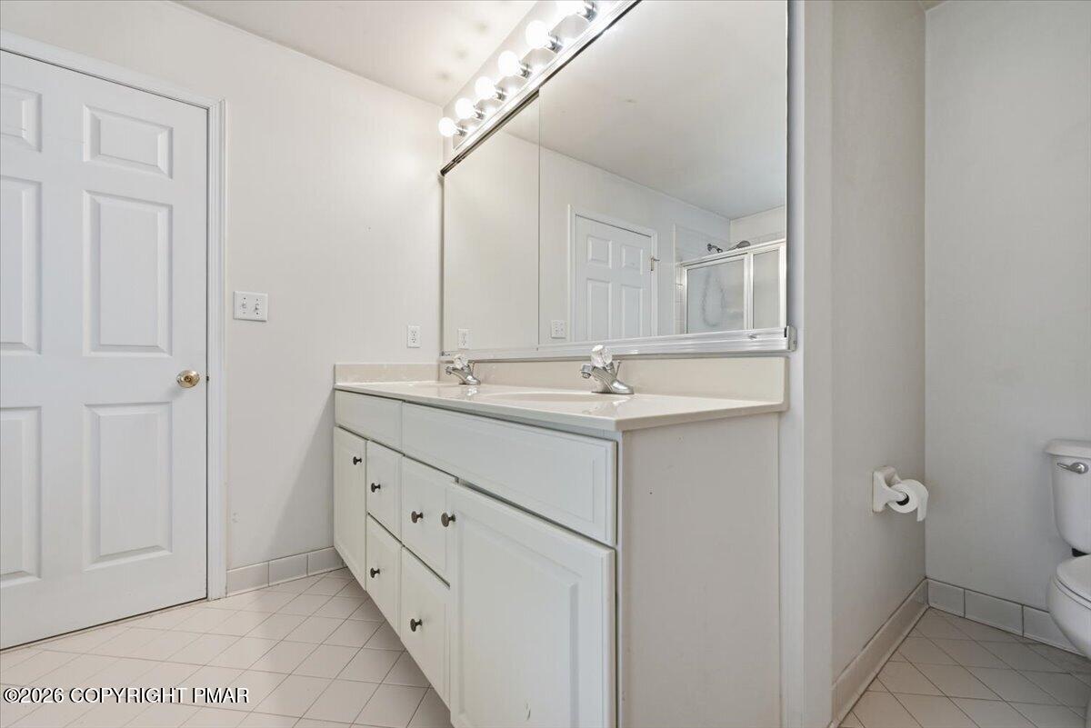 Bathroom with double-sink vanity, large mirror, and overhead vanity lights.