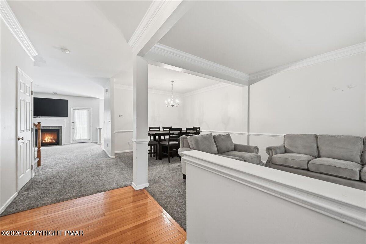 Open living and dining area with gray sofas and a fireplace in the adjoining room.