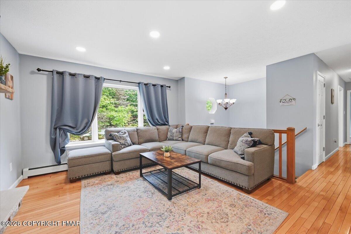 Living room with a gray sectional, wood coffee table, patterned rug, and hardwood floors.
