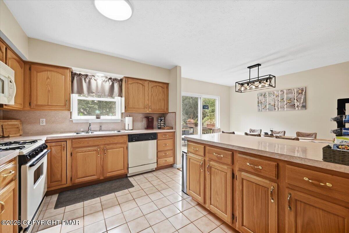 Kitchen with oak cabinetry, a large central island, and sliding glass doors beside the dining area.