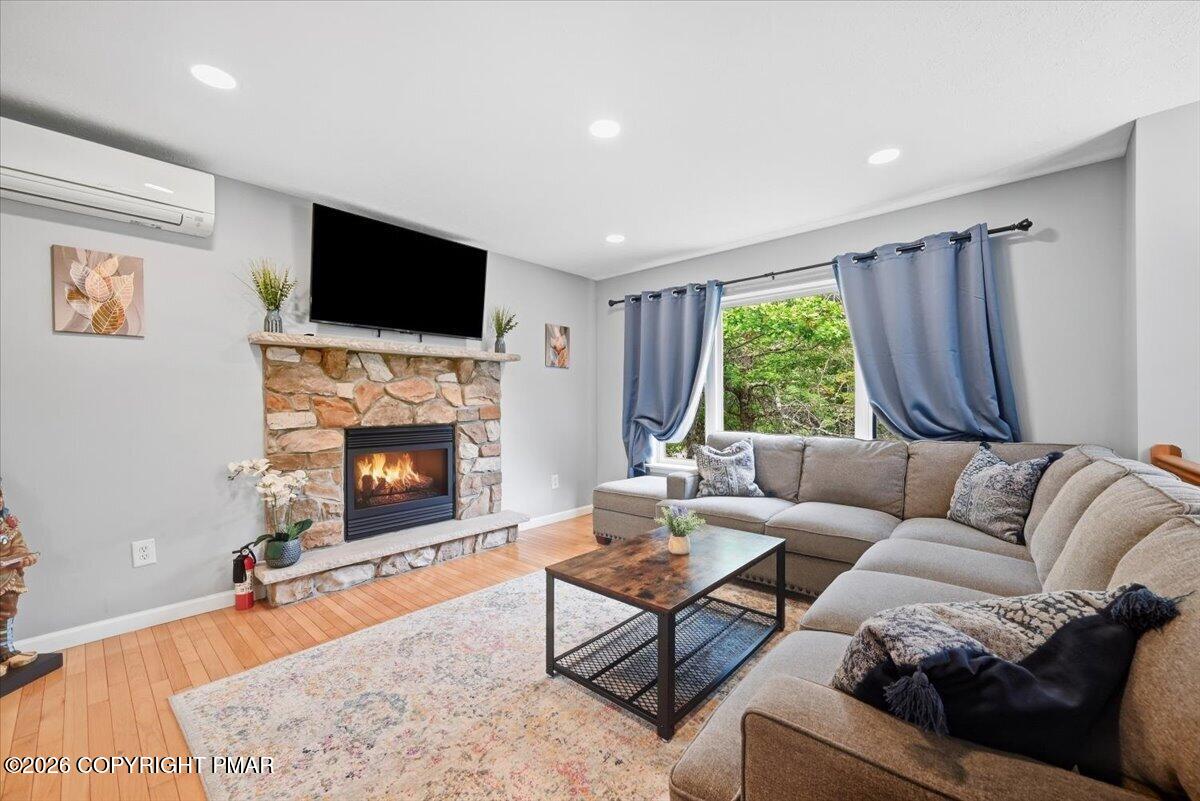 Living room with a stone fireplace, beige sectional, and blue curtains beside a window.