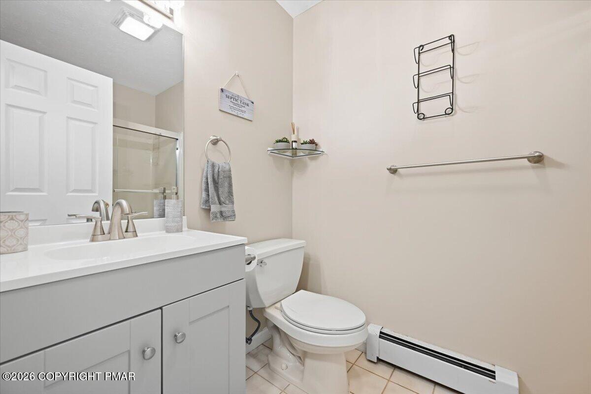 Bathroom with a white vanity, toilet, and glass-enclosed shower.
