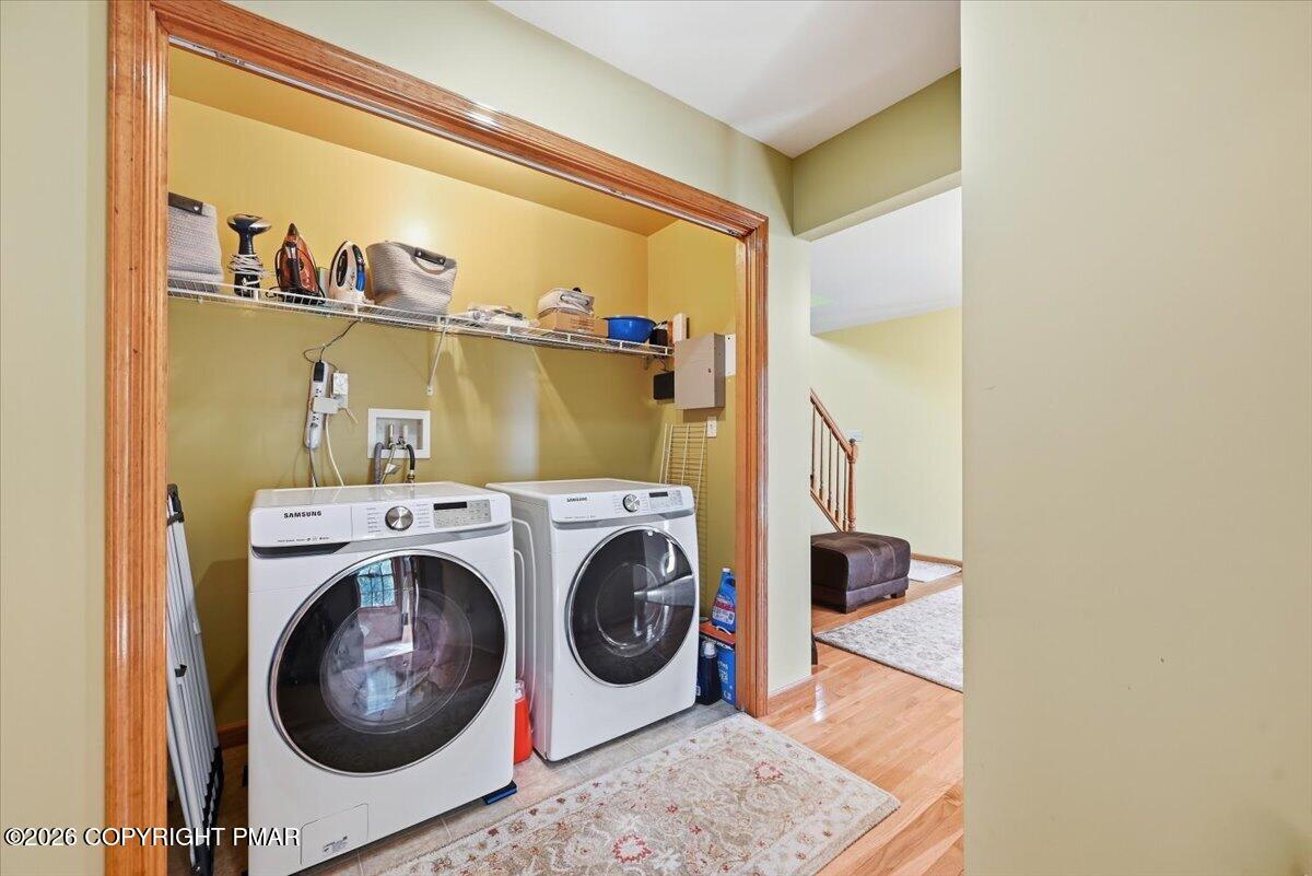 Laundry area with front-loading washer and dryer beneath an open storage shelf.