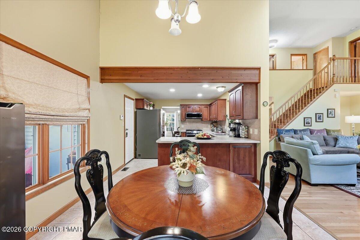 Dining area with a round wood table opens to the kitchen and living room.