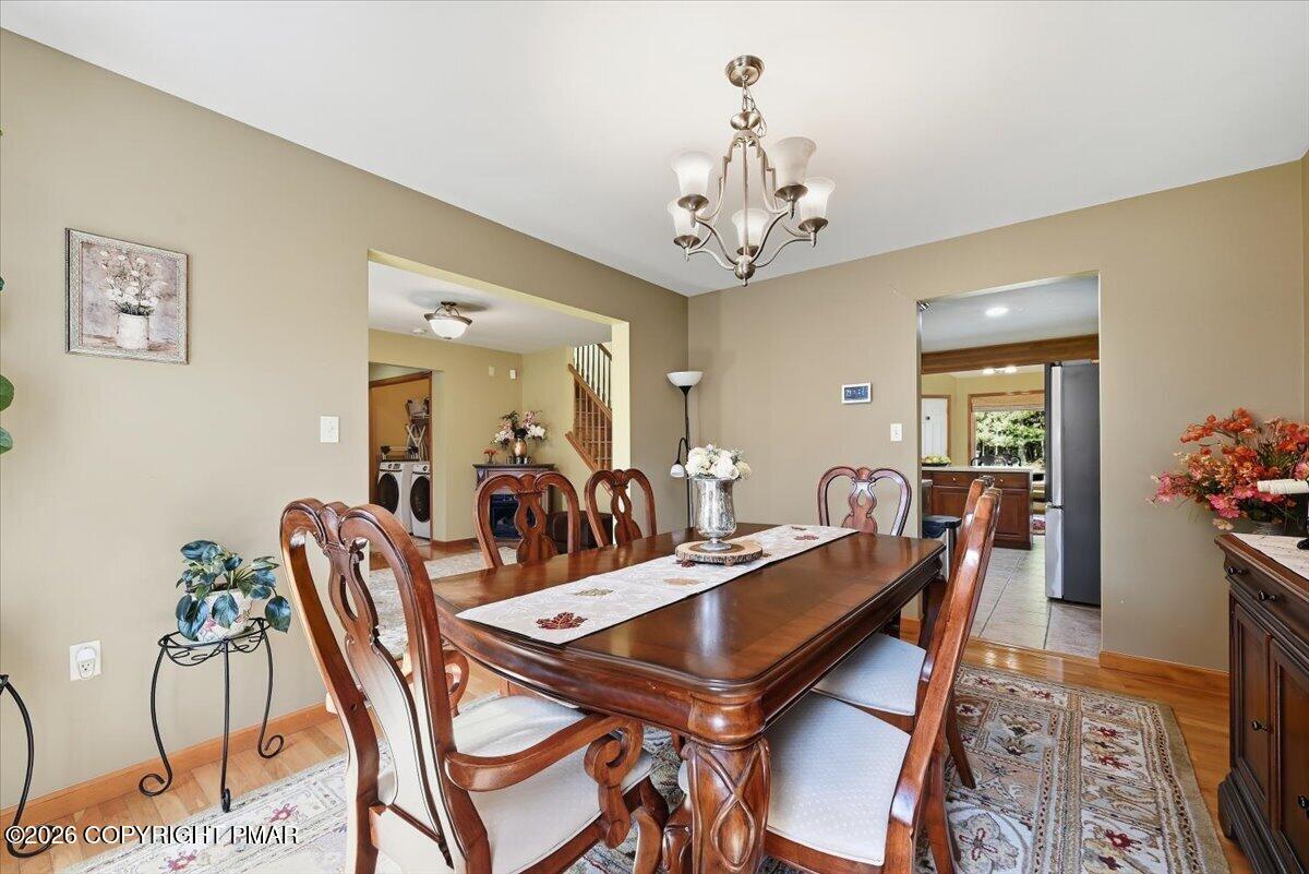 Dining room with a large wooden table, carved chairs, and a chandelier.