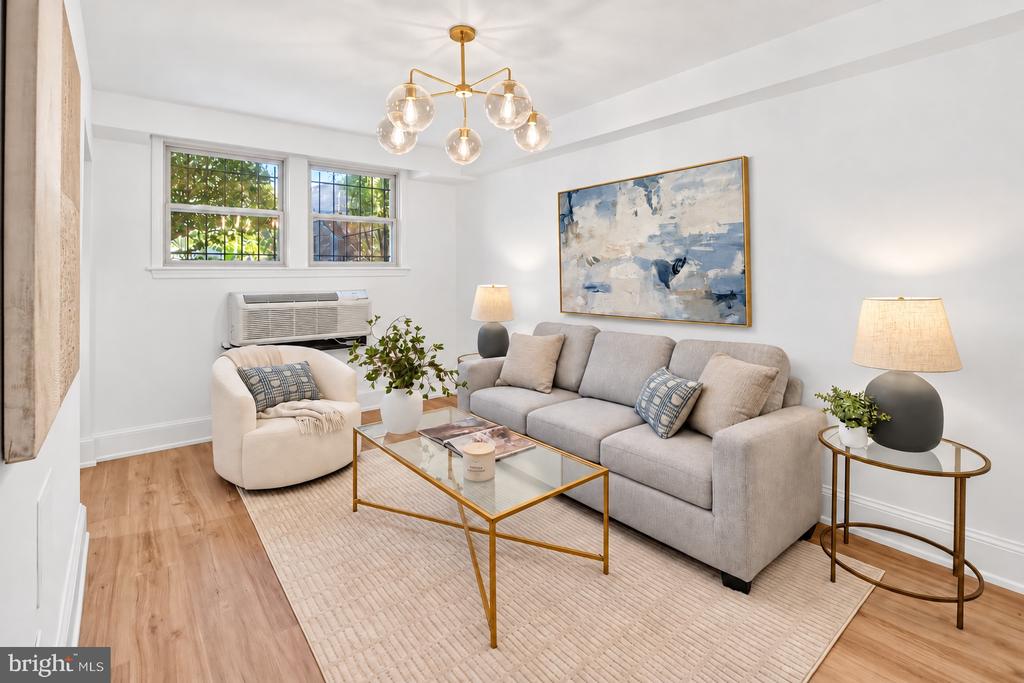 Living room with a gray sofa, gold-framed coffee table, and large abstract painting.