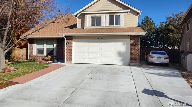 Two-story brick-and-siding home with a wide concrete driveway and attached double garage.