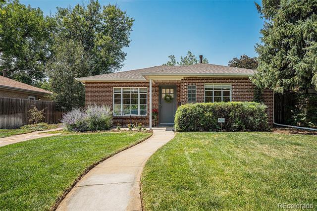 Single-story brick house with a curved walkway leading through the front lawn to the entrance.