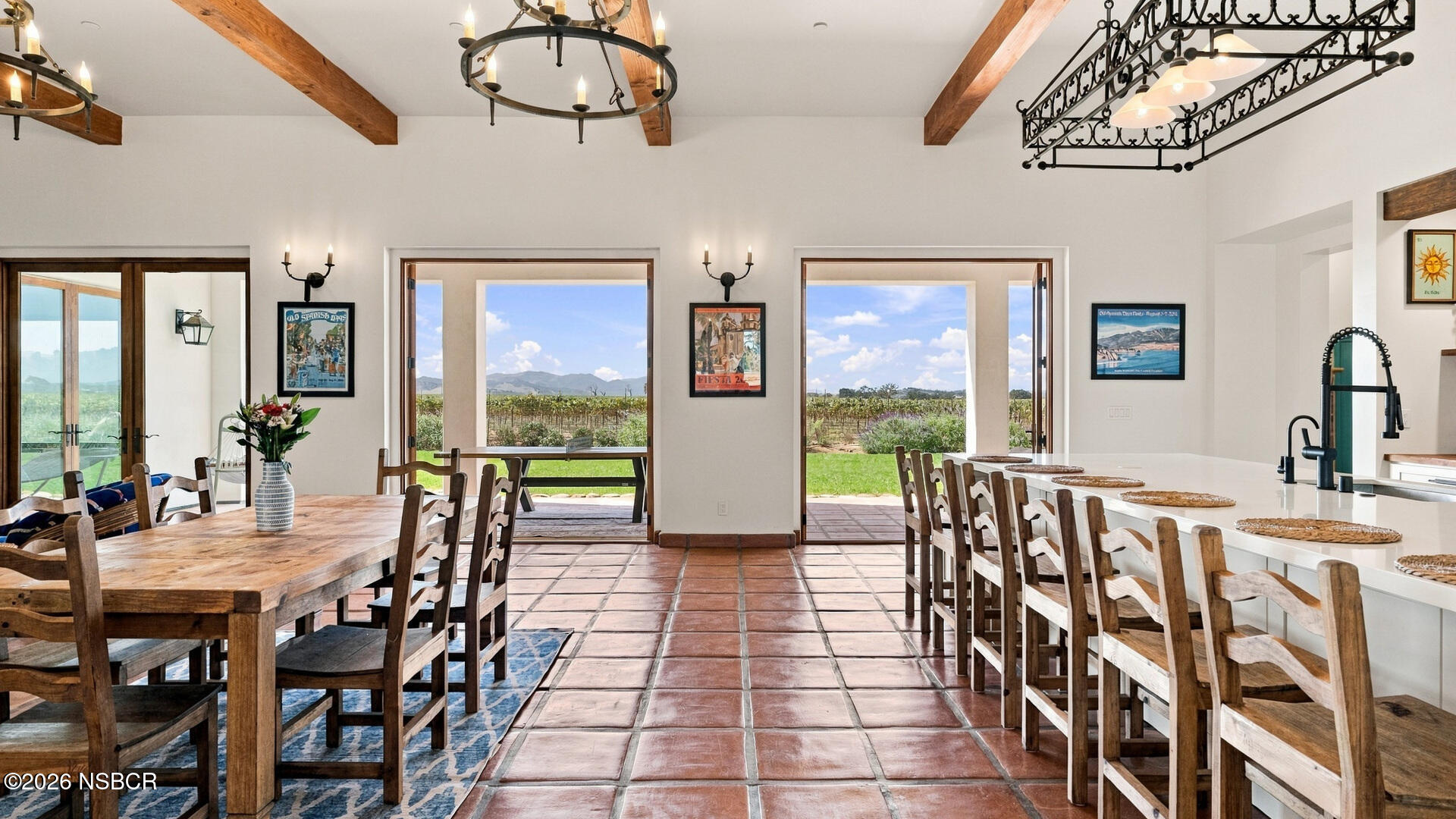 Kitchen and dining area with terracotta tile, a long island, and vineyard views.