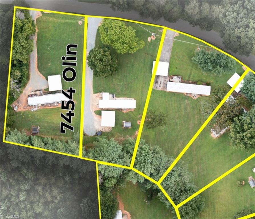 Aerial view of 7454 Olin Road, outlined in yellow among neighboring properties and wooded areas.