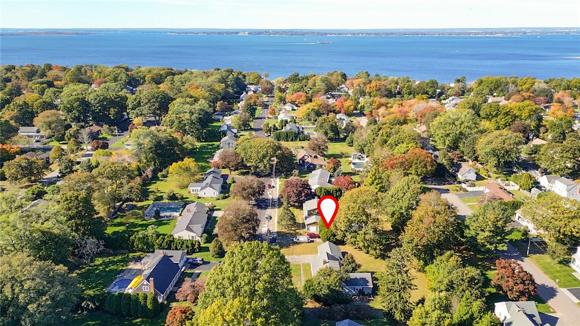 Aerial neighborhood view with a red pin marking a home near the water.