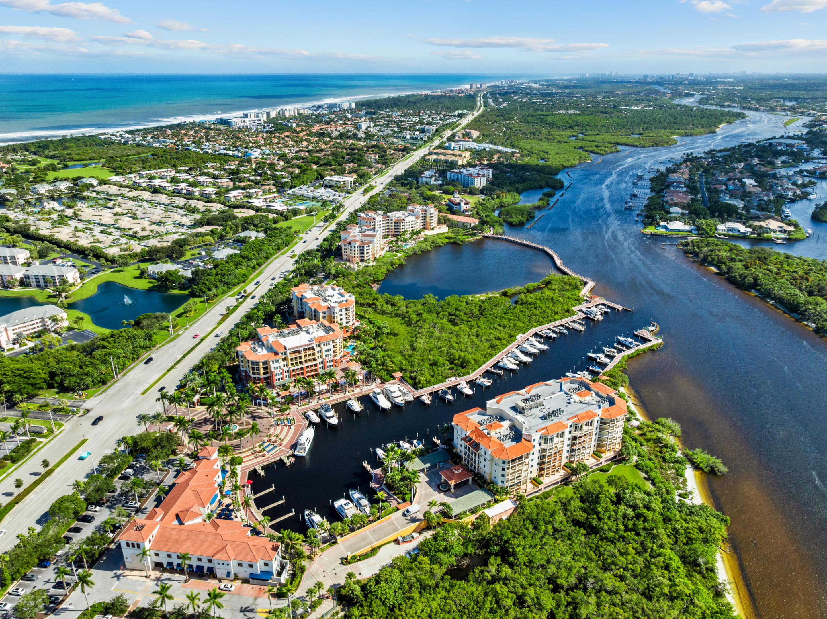 Aerial view of a waterfront marina community, with boats, mangroves, and the Atlantic coast.