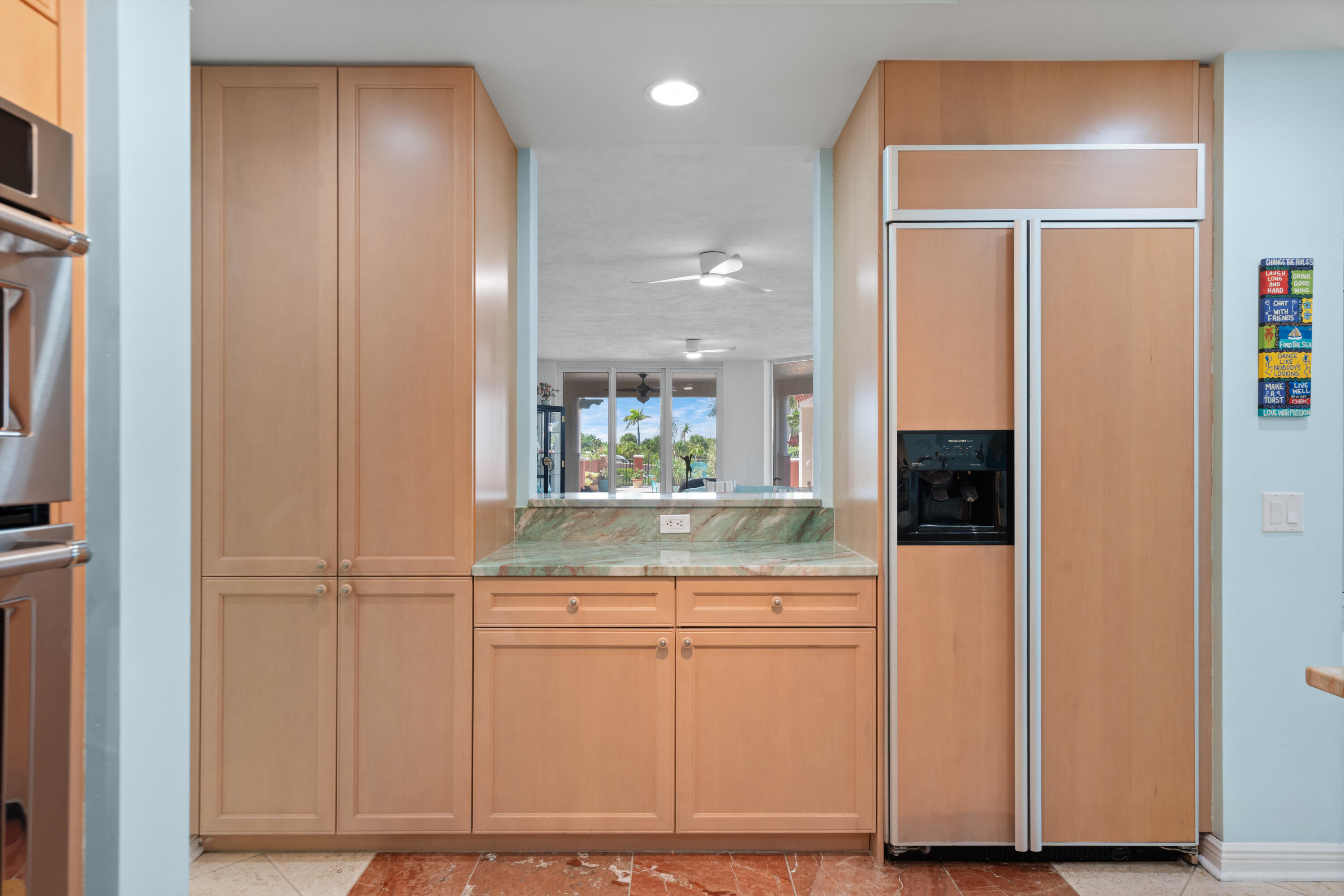 Kitchen with warm wood cabinets, a stone counter, and a view through to the patio.