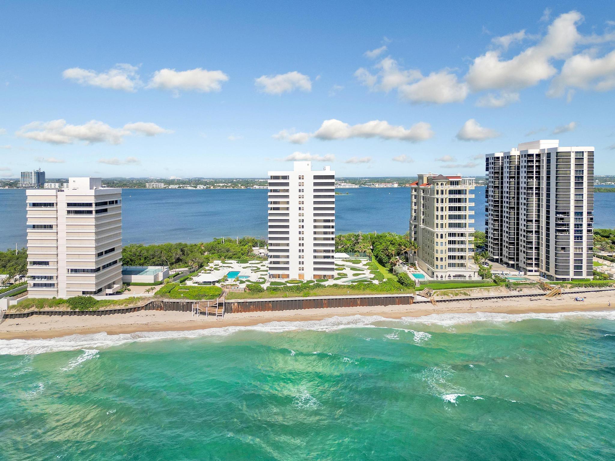 Beachfront condominium towers overlooking turquoise ocean and sandy shoreline.
