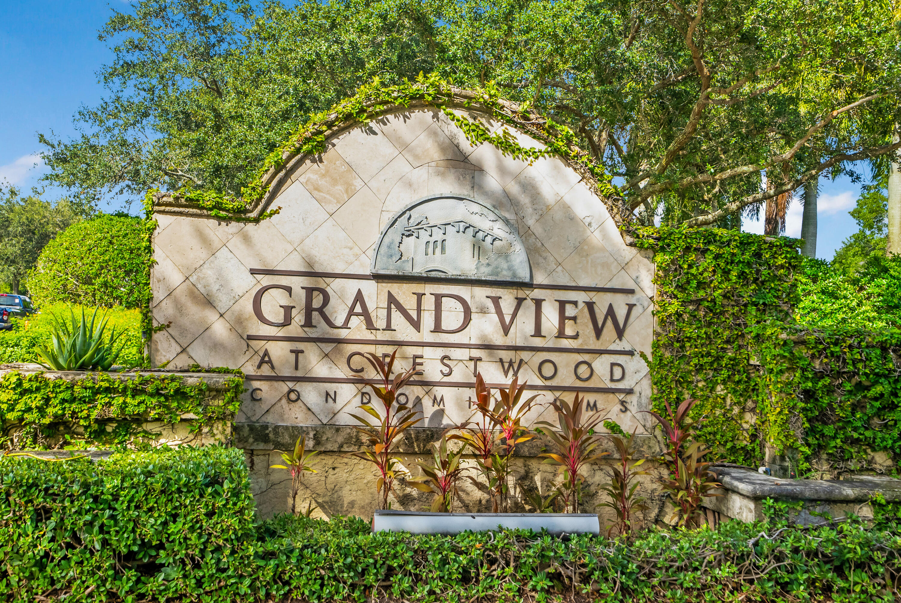 Grand View at Crestwood Condominiums entrance sign surrounded by lush landscaping.