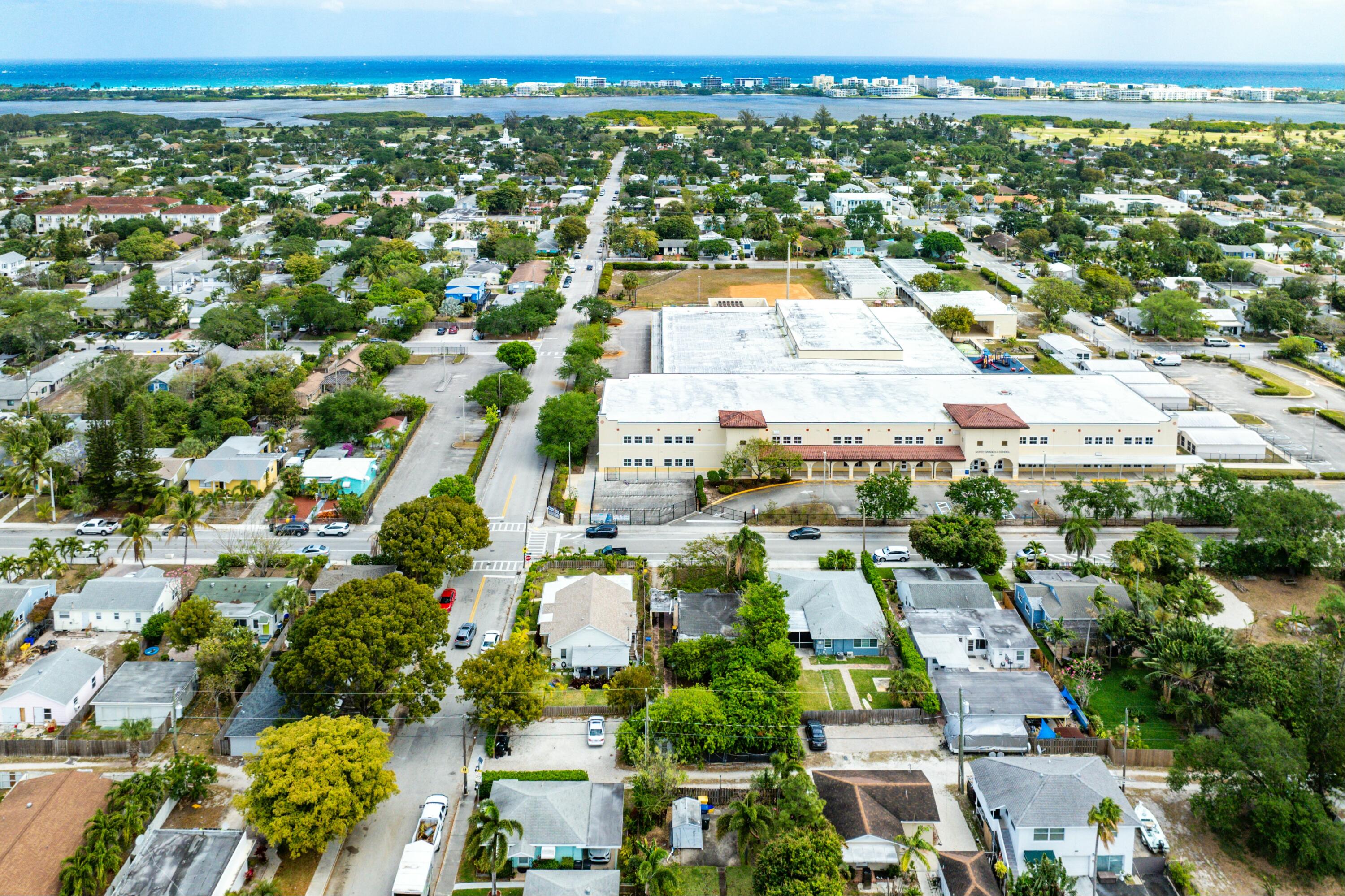 Aerial view of a Lake Worth Beach neighborhood, with a large institutional building and ocean beyond.