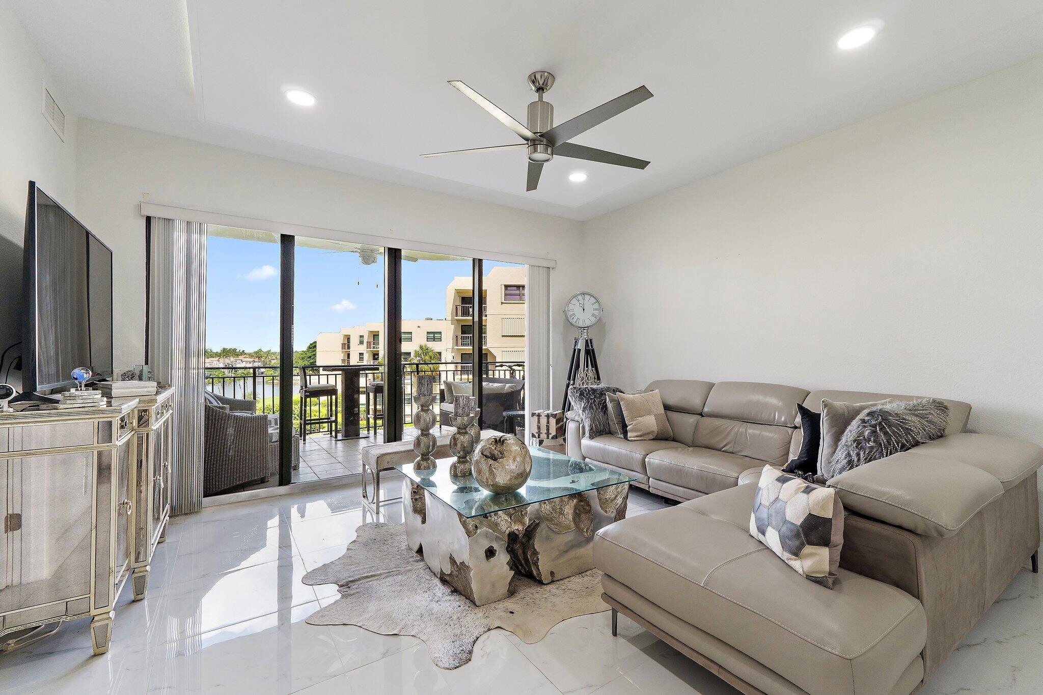 Furnished living room with a taupe sectional and glass doors opening to a balcony.