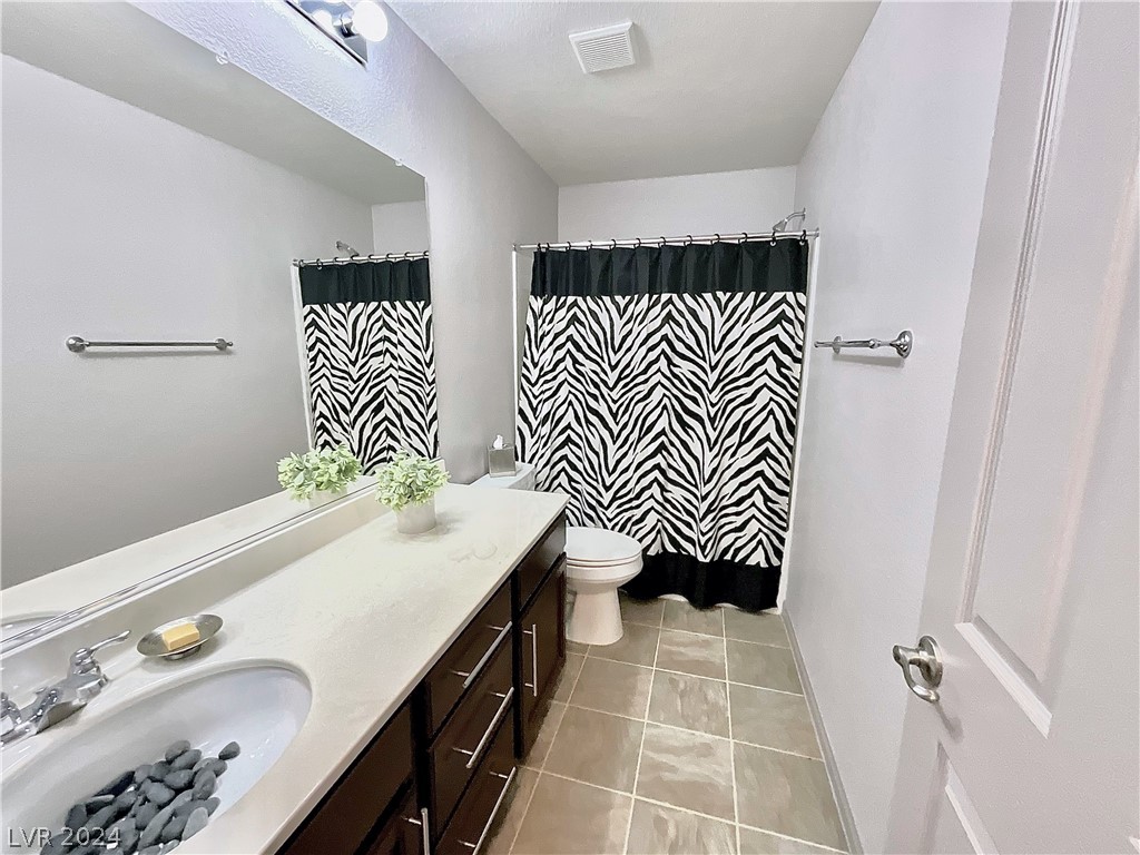 Bathroom with a long dark vanity and black-and-white zebra-pattern shower curtain.