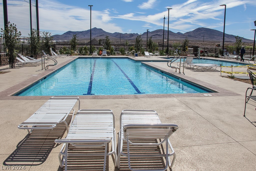Outdoor swimming pool with lap lanes, lounge chairs, and mountain views.