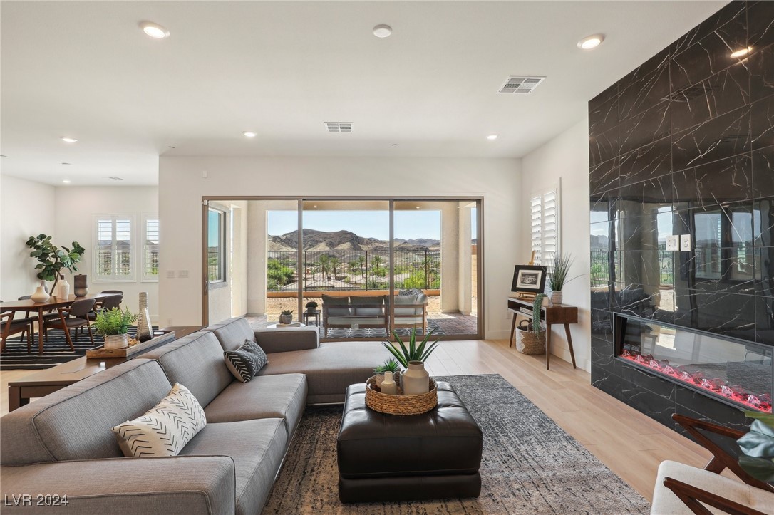 Living room with a gray sectional, marble fireplace wall, and mountain views through sliding glass doors.