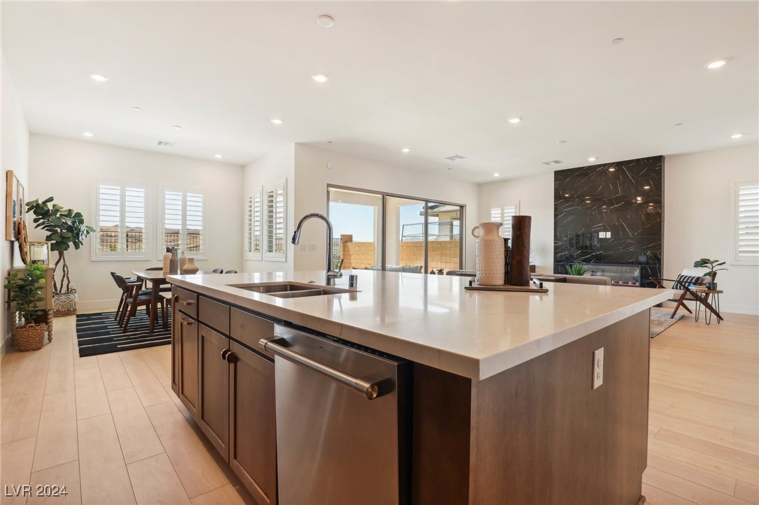 Open-plan kitchen with a large island, dark cabinetry, and sliding doors to a walled patio.