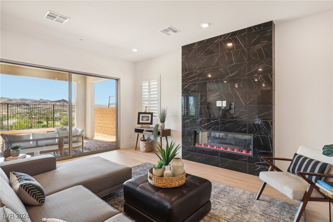 Living room with a dramatic marble fireplace and sliding doors overlooking a mountain-view balcony.