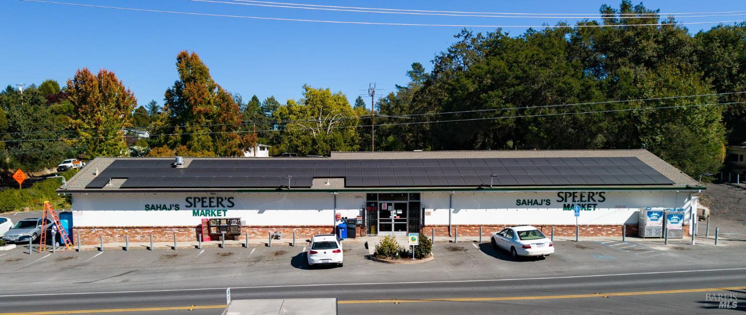 Sahaj's Speer's Market with rooftop solar panels and cars parked outside.