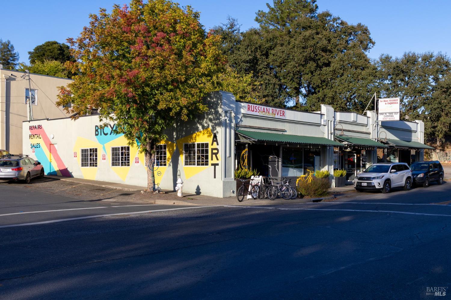 Forestville storefronts with colorful bicycle-shop murals and the Russian River shop sign.
