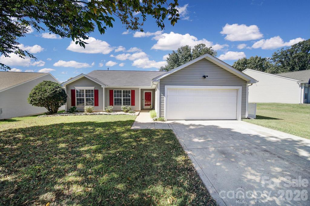 Single-story gray house with red shutters, a red front door, and a two-car garage.