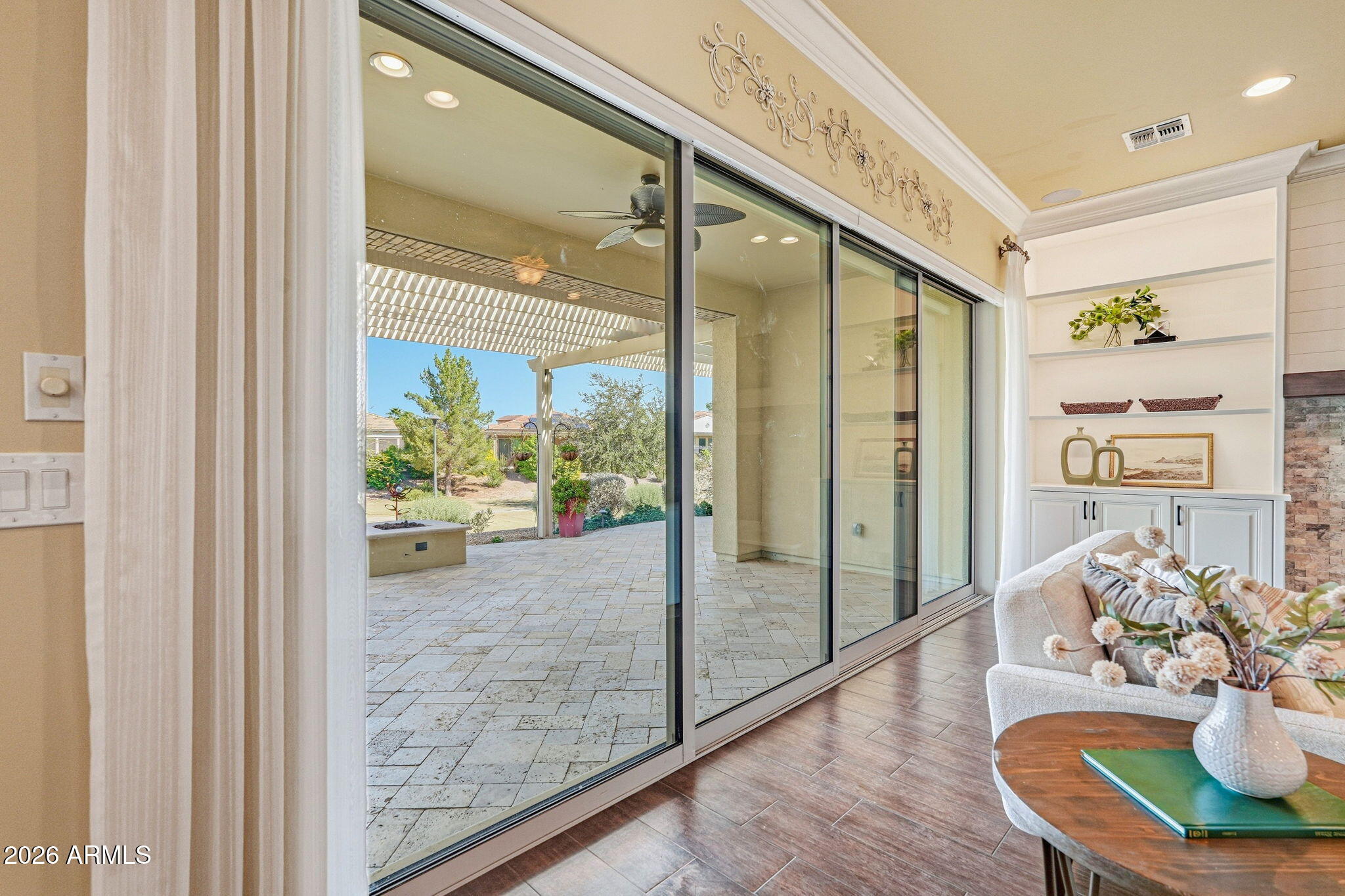 Living room with wide sliding glass doors opening to a covered patio and landscaped backyard.