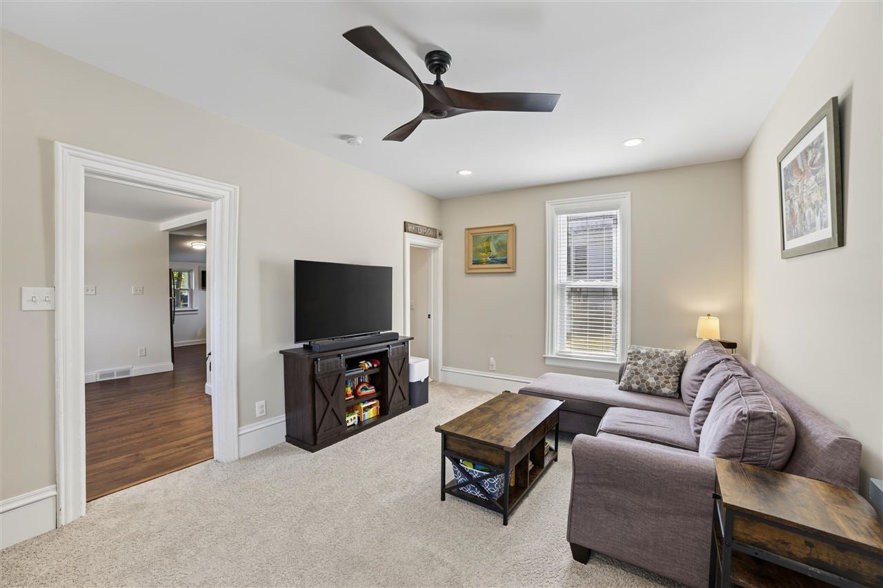 Living room with a gray sectional sofa, dark wood coffee table, and TV on a console.