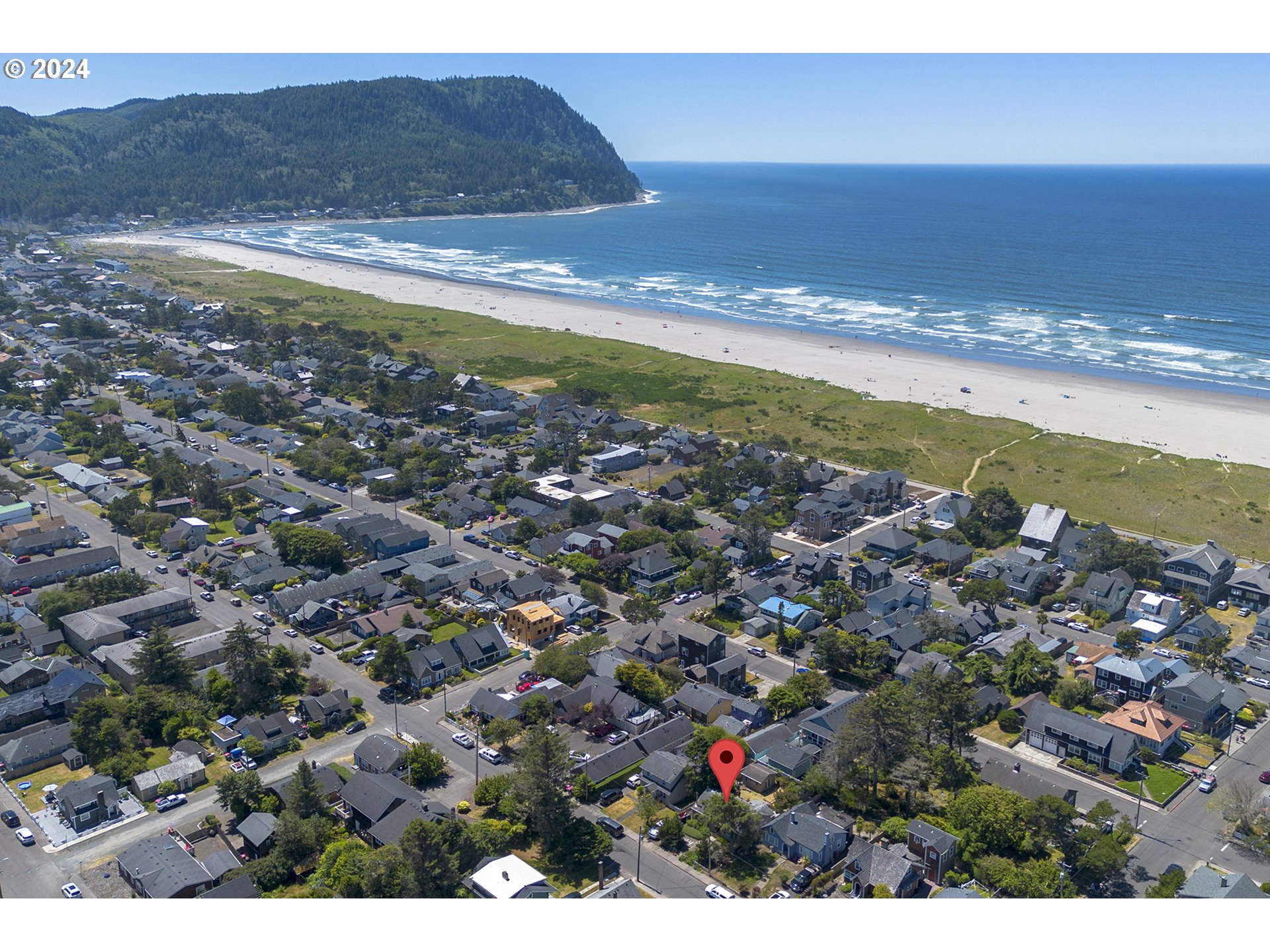 Aerial view of the neighborhood, with a location pin among homes near the beach and ocean.