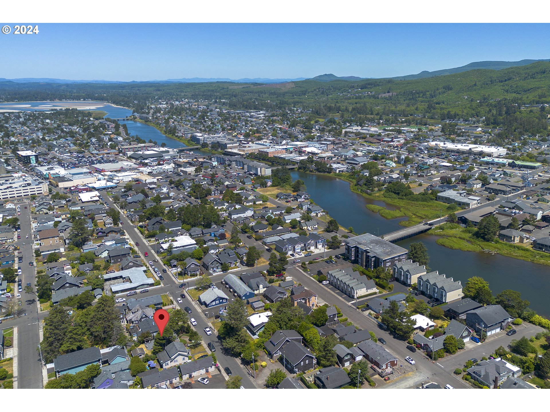 Aerial view of a Seaside neighborhood, with a red pin marking a home near the river.