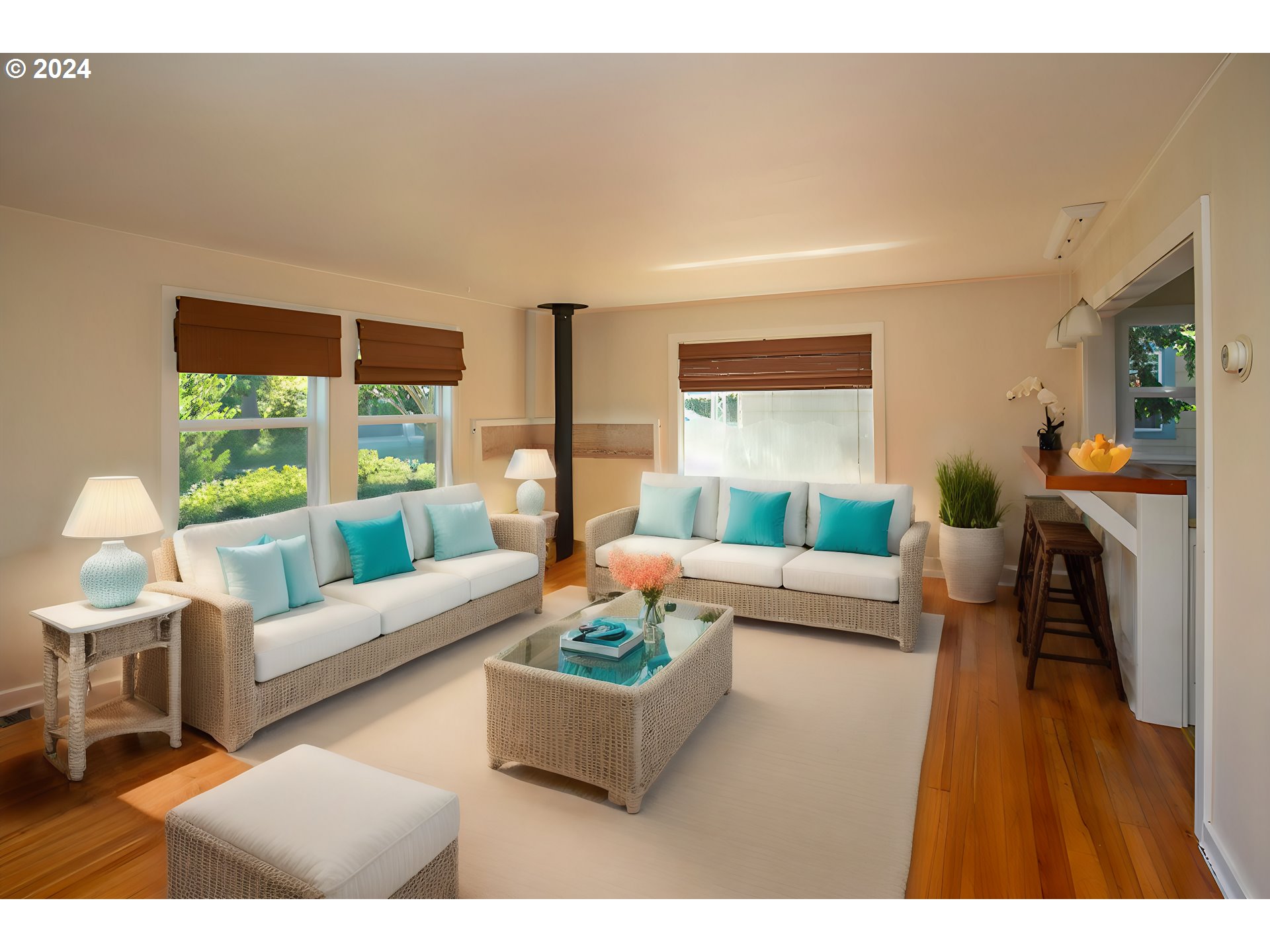 Living room with white rattan sofas, turquoise pillows, a black stove, and hardwood floors.