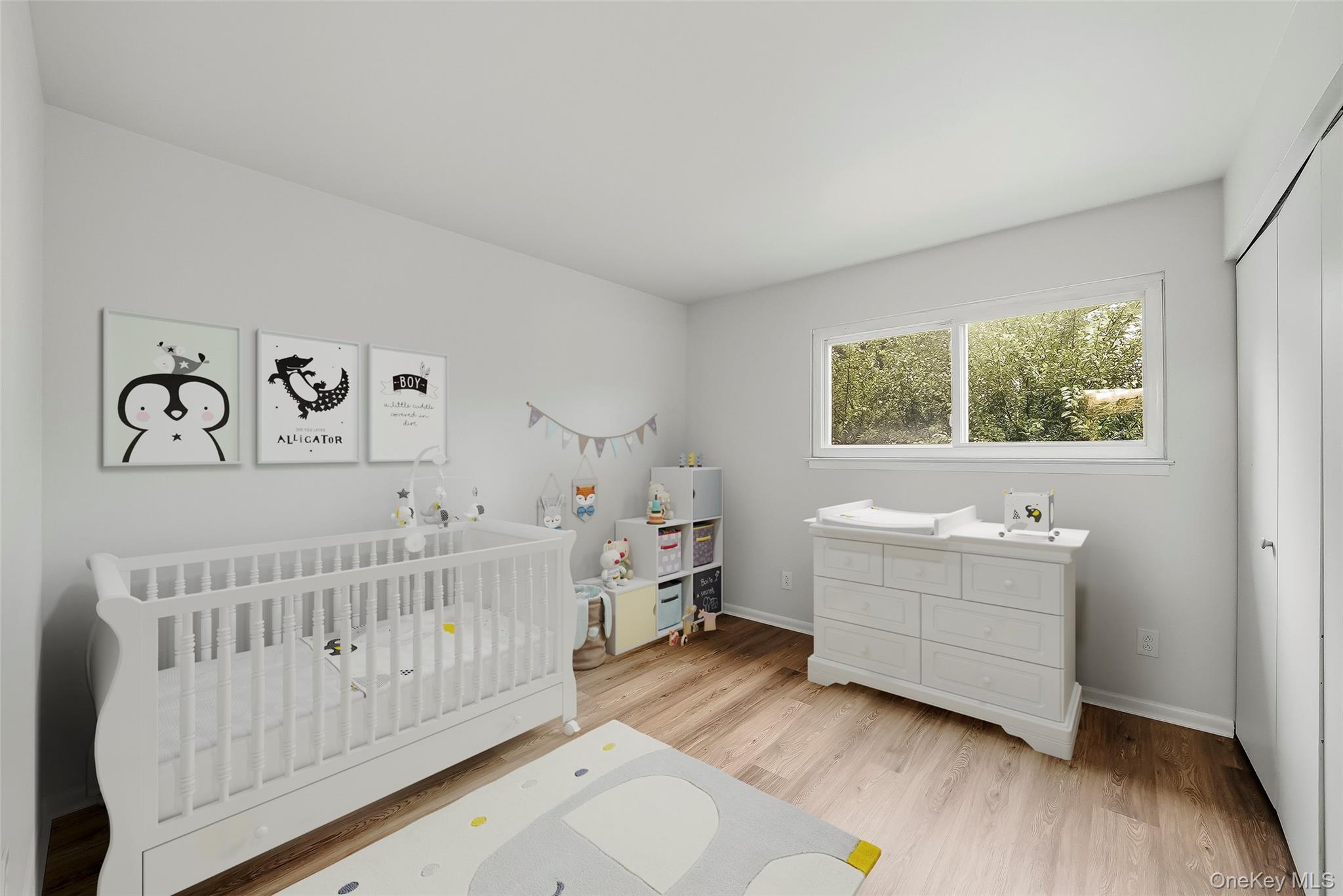 Nursery with a white crib, changing dresser, animal prints, and light wood flooring.
