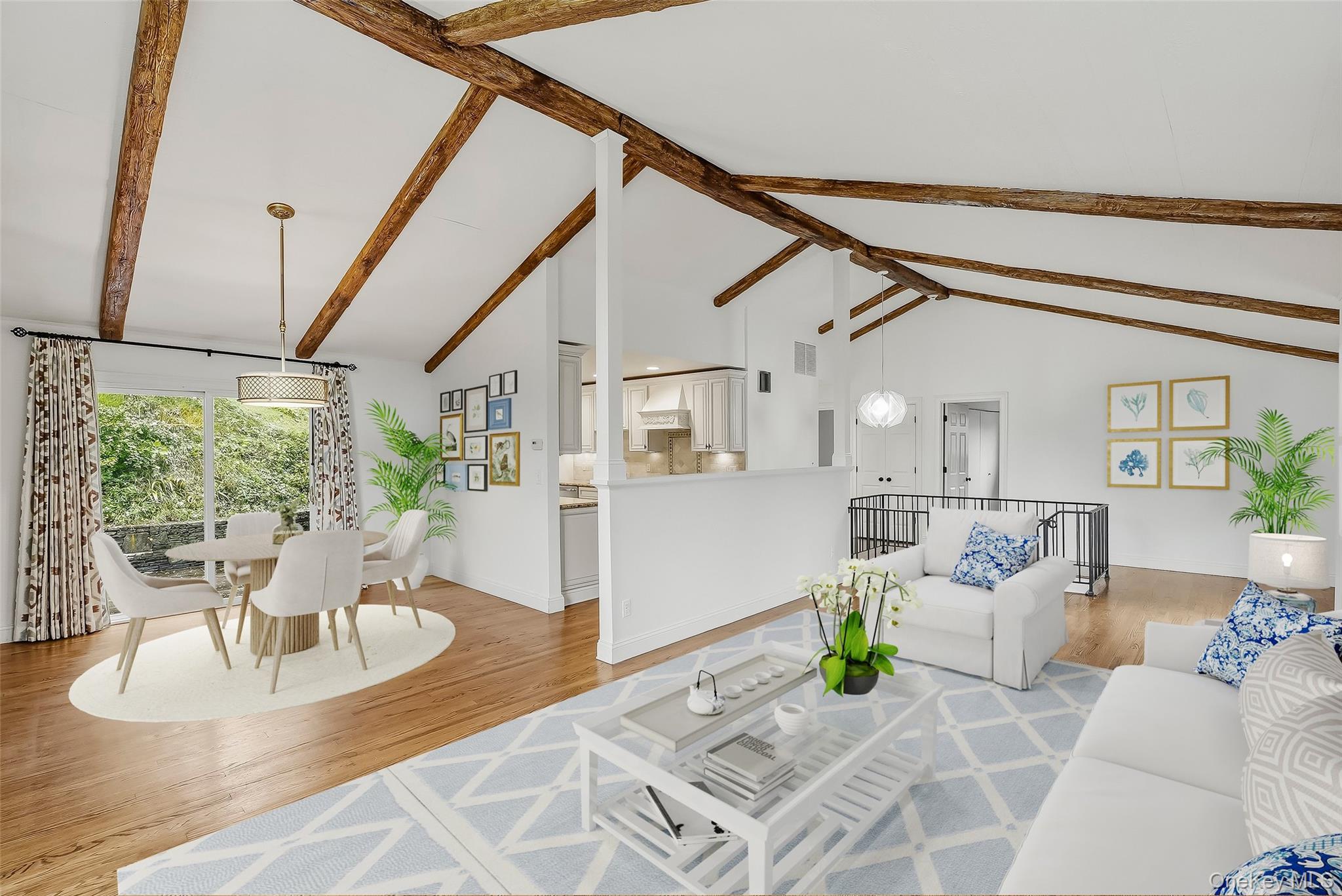 Open-plan living and dining room with vaulted ceilings, exposed wood beams, and sliding glass doors.