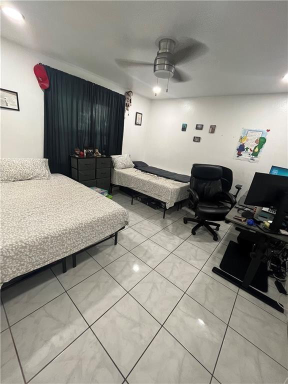 Bedroom with two single beds, dark curtains, tiled floors, and a computer desk.