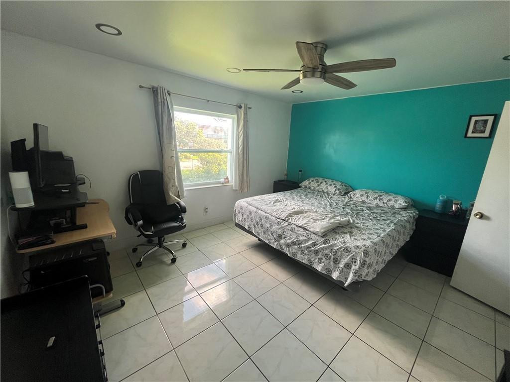 Bedroom with a bed against a teal accent wall and a desk beside the window.