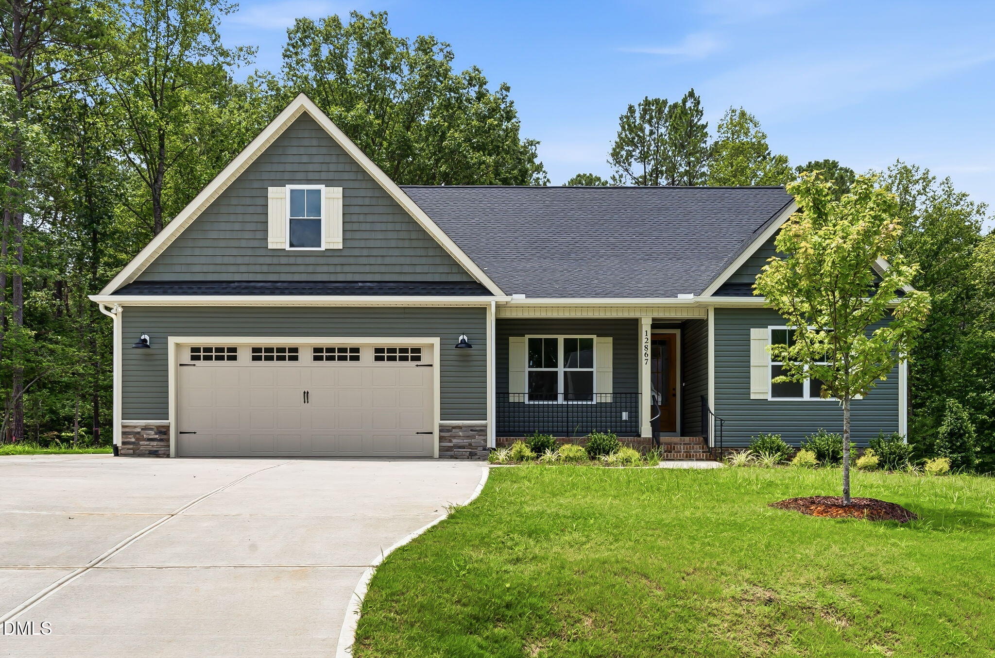 Gray-green house with a steep front gable, cream-trimmed two-car garage, and covered porch.