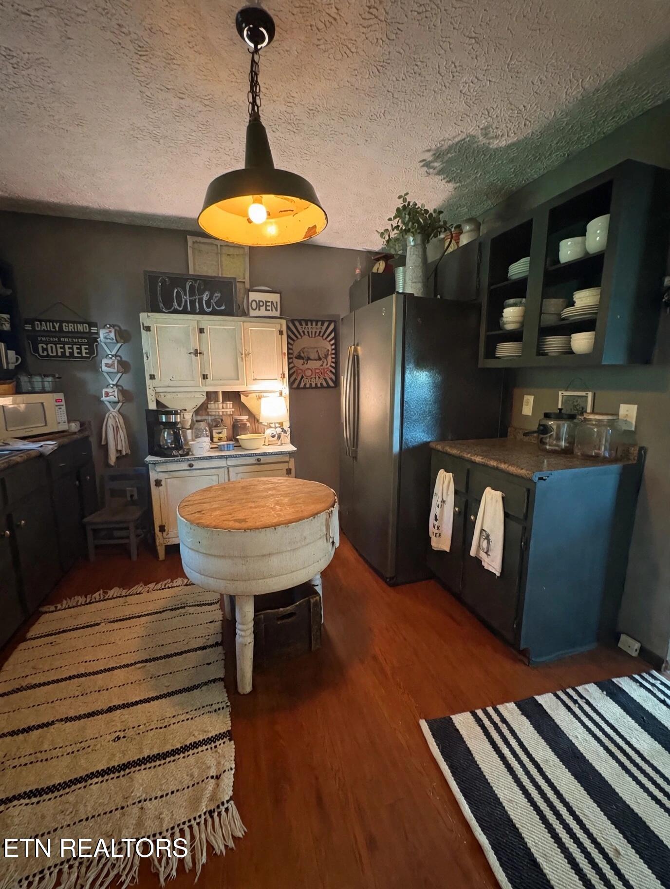 Kitchen with a vintage coffee station, glass-front cabinets, and a round island.