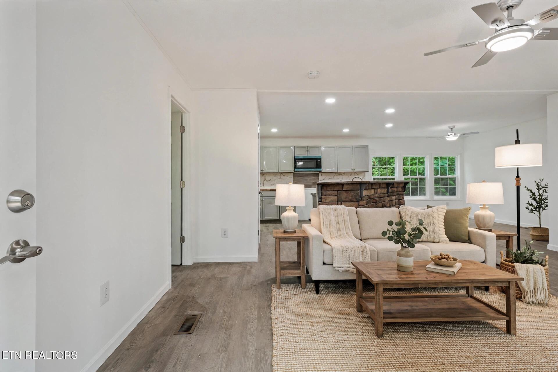 Staged living room with a cream sofa and stone-faced kitchen island.