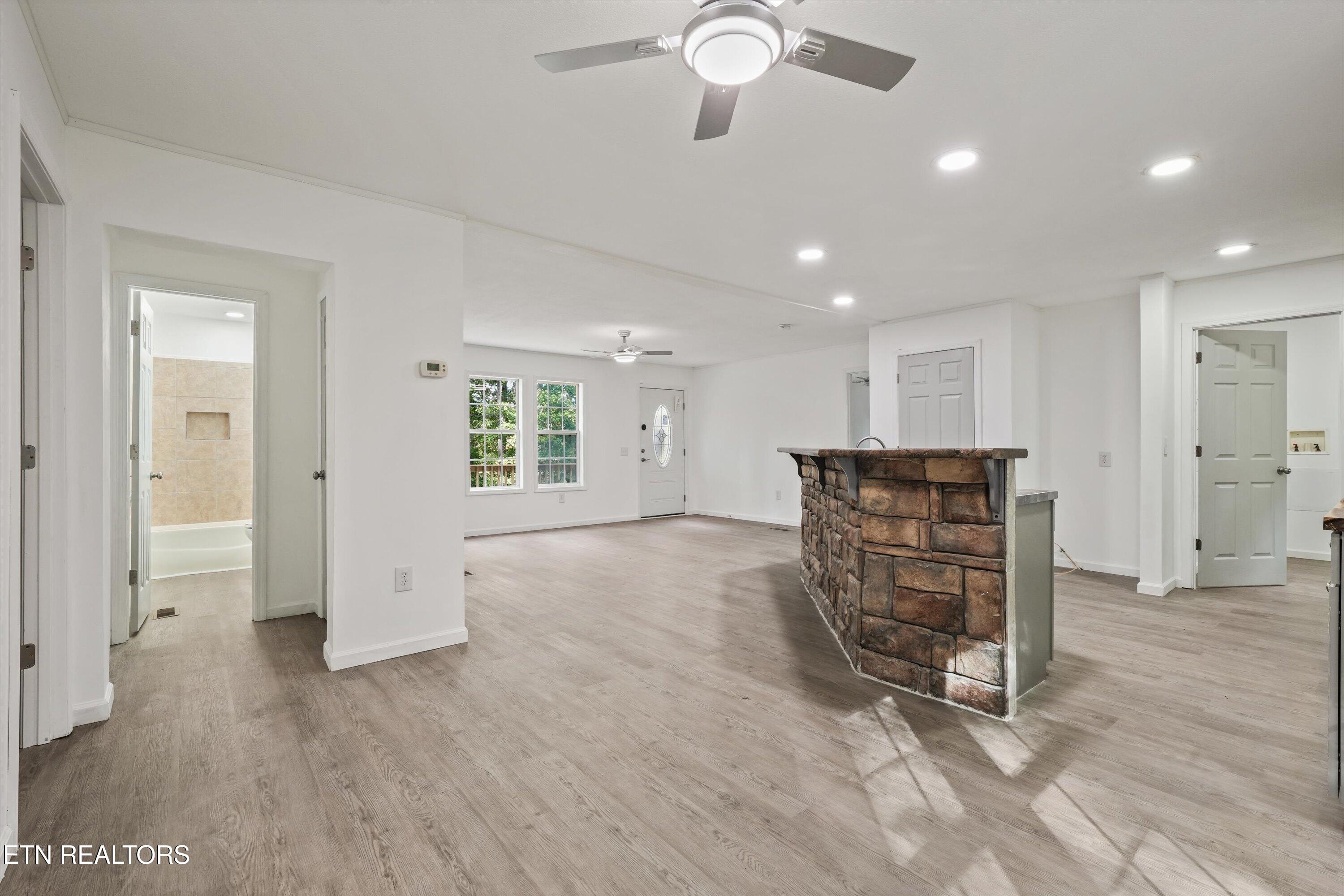 Open-plan living area with gray flooring and a prominent stone-faced kitchen counter.