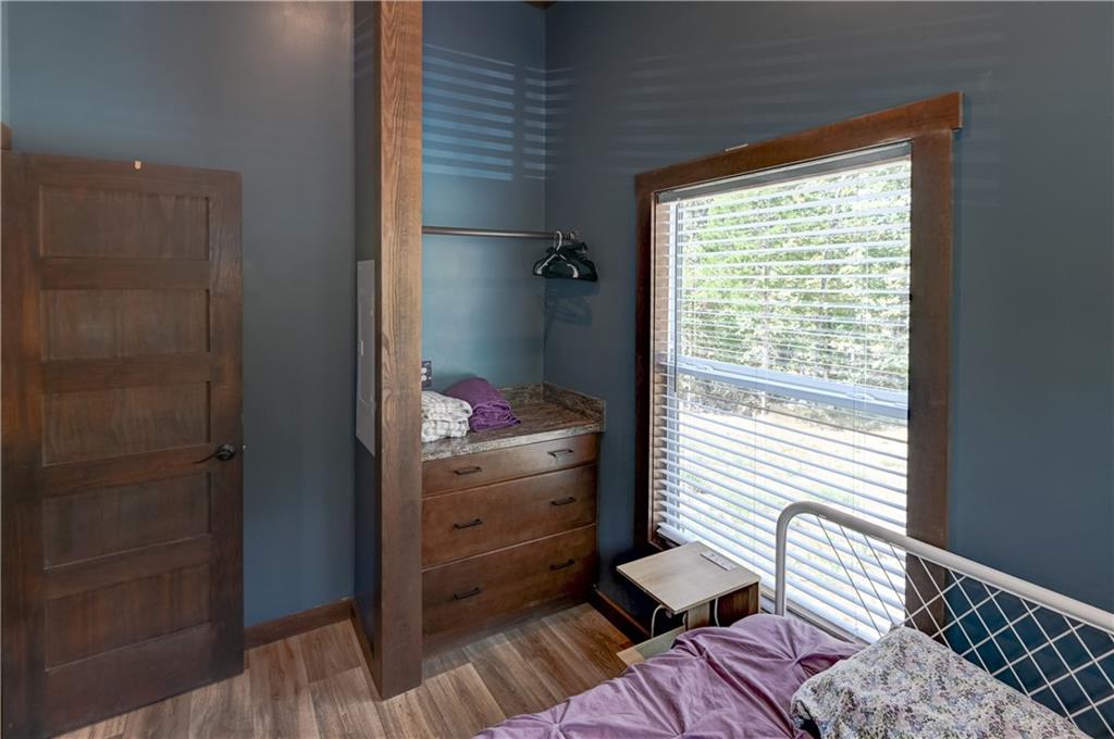 Bedroom with blue walls, a built-in wooden dresser, and a large window with blinds.