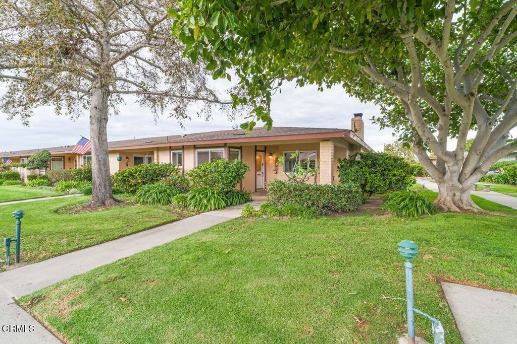 Single-story home with a covered entry, mature trees, and landscaped lawn in Hueneme Bay.